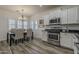 Open concept dining area with stainless steel appliances, wood-look flooring, and modern lighting at 19323 E Canary Way, Queen Creek, AZ 85142