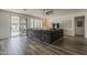 Bright living room with sliding glass doors, wood-look floors, and a large gray sofa at 19323 E Canary Way, Queen Creek, AZ 85142