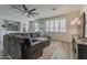 Inviting living room with wood-look floors, plantation shutters, and a large sectional sofa at 19323 E Canary Way, Queen Creek, AZ 85142