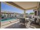 Relaxing covered patio with stylish furniture overlooking a refreshing pool and backyard at 19323 E Canary Way, Queen Creek, AZ 85142