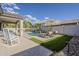 Backyard featuring a pool with waterfall feature, lounge chairs, and patio at 19323 E Canary Way, Queen Creek, AZ 85142