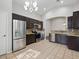 Spacious kitchen with stainless steel appliances, granite countertops, dark cabinetry, and tile flooring at 21533 N Greenway Rd, Maricopa, AZ 85138
