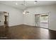 Bright living room with high ceilings, ceiling fan, wood-look tile flooring, and sliding doors to the patio at 21533 N Greenway Rd, Maricopa, AZ 85138