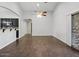 Open living area features wood-look tile flooring, a ceiling fan, and access to kitchen and patio at 21533 N Greenway Rd, Maricopa, AZ 85138