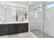 Modern bathroom with a double vanity, framed mirrors, and a glass-enclosed shower with seating and white subway tile at 22023 N 28Th Pl, Phoenix, AZ 85050