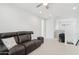 Bright bonus room featuring a brown leather reclining sofa, ceiling fan, and an adjacent loft area at 22023 N 28Th Pl, Phoenix, AZ 85050