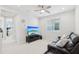 Comfortable bonus room featuring a brown leather reclining sofa, ceiling fan, and large television at 22023 N 28Th Pl, Phoenix, AZ 85050