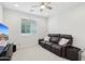 Bonus room with a ceiling fan, a brown leather reclining sofa, and a large window for natural light at 22023 N 28Th Pl, Phoenix, AZ 85050