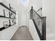 Inviting entryway with wood-look flooring, black shelving for decor, and stairway with black rails, under a skylight at 22023 N 28Th Pl, Phoenix, AZ 85050
