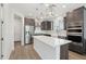 Bright kitchen features stainless appliances, island with white countertop, and modern pendant lighting at 22023 N 28Th Pl, Phoenix, AZ 85050