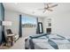 Bright main bedroom featuring a large window, ceiling fan, chair with books, and stylish blue accent wall at 22023 N 28Th Pl, Phoenix, AZ 85050