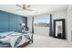 Bright main bedroom with large window, stylish blue accent wall, and a modern ceiling fan at 22023 N 28Th Pl, Phoenix, AZ 85050