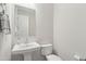 Clean half bath features a pedestal sink, modern faucet and a crisp white toilet at 22023 N 28Th Pl, Phoenix, AZ 85050