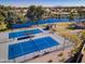 An aerial view of tennis courts by the community lake, showcasing the neighborhood's recreational amenities and scenic views at 2511 W Queen Creek Rd # 374, Chandler, AZ 85248