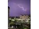 Night view of a charming community featuring illuminated streets under a dramatic lightning-filled sky at 2511 W Queen Creek Rd # 374, Chandler, AZ 85248
