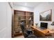 Cozy home office featuring built-in shelving, a wood desk, and comfortable black leather office chair at 2511 W Queen Creek Rd # 374, Chandler, AZ 85248
