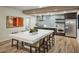 This dining and kitchen area features modern stainless steel appliances and a central island with a white countertop at 2511 W Queen Creek Rd # 374, Chandler, AZ 85248