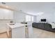 Open concept living area with light wood flooring, a gray couch and access to the modern kitchen at 2511 W Queen Creek Rd # 374, Chandler, AZ 85248
