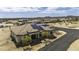 Aerial view of a home with solar panels, surrounded by desert landscaping and a long driveway at 2751 N Ralston Rd, Maricopa, AZ 85139