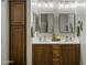 Bathroom featuring double sinks, wood cabinetry and a linen closet for storage at 2751 N Ralston Rd, Maricopa, AZ 85139