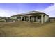 Exterior shot shows covered patio with stylish doors, with grill and seating area, and desert yard at 2751 N Ralston Rd, Maricopa, AZ 85139