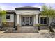 Charming front porch with rocking chairs, tile accents, potted plants and iron security doors at 2751 N Ralston Rd, Maricopa, AZ 85139