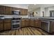 Kitchen features wood floors, stainless steel appliances, and wooden cabinets at 2751 N Ralston Rd, Maricopa, AZ 85139