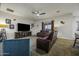Comfortable living room featuring a large TV, plush seating, a ceiling fan, and neutral decor at 2751 N Ralston Rd, Maricopa, AZ 85139