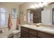 Bathroom with double sinks, decorative mirror, and natural light from window with shutters at 2917 E Northridge St, Mesa, AZ 85213