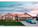 Charming single-story home with a blue door, lush lawn, mature plants and an attached two-car garage at 2917 E Northridge St, Mesa, AZ 85213