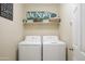 Laundry room features a shelf with decorative accents and a full-size washer and dryer at 2917 E Northridge St, Mesa, AZ 85213