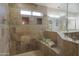 Luxurious travertine tiled shower with glass enclosure, seating, and rainfall shower head at 2917 E Northridge St, Mesa, AZ 85213