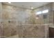 Luxurious travertine tiled shower with glass enclosure and rainfall shower head at 2917 E Northridge St, Mesa, AZ 85213