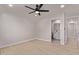 Minimalist bedroom with wood floors, ceiling fan, and ensuite bathroom access at 2926 E Corrine Dr, Phoenix, AZ 85032