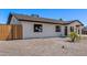 Side view of a modern white home with a dark roof, stylish landscaping, and wooden fence at 2926 E Corrine Dr, Phoenix, AZ 85032