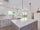 Bright modern kitchen with white cabinets, quartz counters, stainless appliances and gray island with bar seating at 2926 E Corrine Dr, Phoenix, AZ 85032
