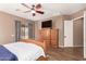 Bedroom features a wooden bed frame, a large dresser with a TV, and an open door to the hallway at 2945 E Clifton Ave, Gilbert, AZ 85295