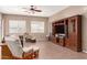 Spacious living room featuring tile flooring, ceiling fan, natural light, and a large entertainment center at 2945 E Clifton Ave, Gilbert, AZ 85295