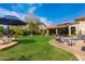 Spacious backyard featuring manicured lawn, patio seating, mature landscaping, and exterior home views at 29506 N 21St Ave, Phoenix, AZ 85085