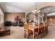 Open-concept dining room with a large wooden table, arched doorway, and cozy living area in the background at 29506 N 21St Ave, Phoenix, AZ 85085