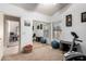 Bright exercise room featuring a mirrored closet and a view into the adjacent office space at 29506 N 21St Ave, Phoenix, AZ 85085