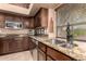 Close-up of a kitchen featuring dark wood cabinets, granite counters, and stainless-steel appliances at 29506 N 21St Ave, Phoenix, AZ 85085