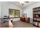 Well-lit home office featuring a dark wood desk and shelving with views from the window at 29506 N 21St Ave, Phoenix, AZ 85085