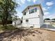 Backyard showcasing a white house, a concrete patio, shade trees, and a white gate at 3215 W Orangewood Ave, Phoenix, AZ 85051