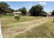 View of a backyard with grass, various trees, and a clear area for a variety of uses at 3215 W Orangewood Ave, Phoenix, AZ 85051