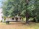 Charming home featuring a large tree, a well-maintained lawn and a quaint front porch with white railings at 3215 W Orangewood Ave, Phoenix, AZ 85051
