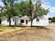 Charming white exterior features a red front door, complemented by a well-kept yard and mature trees at 3215 W Orangewood Ave, Phoenix, AZ 85051