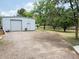 Spacious white garage/workshop surrounded by mature trees, offering ample outdoor space at 3215 W Orangewood Ave, Phoenix, AZ 85051