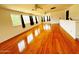 Large living room featuring hardwood floors, multiple windows, and several ceiling fans at 3215 W Orangewood Ave, Phoenix, AZ 85051