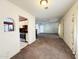 Open-concept living room with a glimpse into the kitchen, and cozy carpeted floors at 3215 W Orangewood Ave, Phoenix, AZ 85051